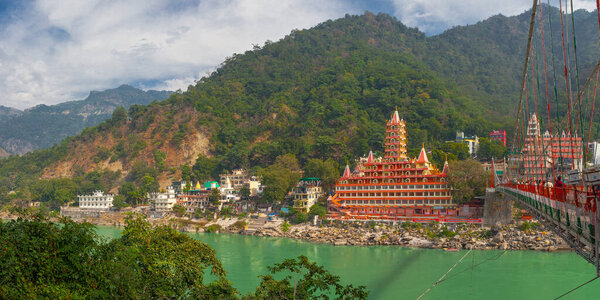 Rishikesh, India - November 21, , 2019. View of Ganga river embankment, Lakshman Jhula bridge and Tera Manzil Temple, Trimbakeshwar in Rishikesh
