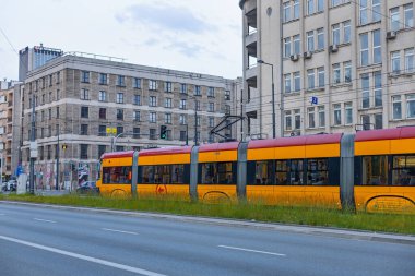 Polonya, Varşova, 14 Haziran 2023: Toplu taşıma için bir tramvay ve otobüs durağı. Otobüsler ve tramvaylar durur, yolcular araçlarını bekler, araçlara biner ve inerler..