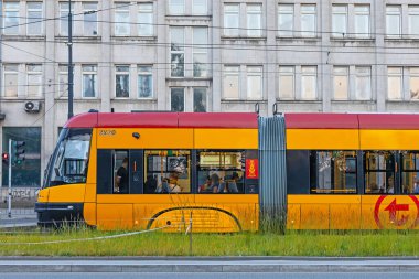 Polonya, Varşova, 14 Haziran 2023: Toplu taşıma için bir tramvay ve otobüs durağı. Otobüsler ve tramvaylar durur, yolcular araçlarını bekler, araçlara biner ve inerler..