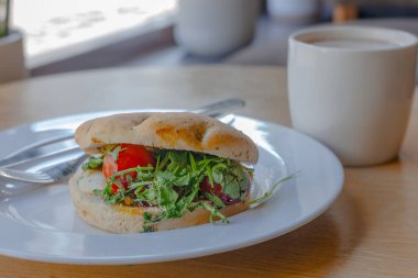 Beyaz tabakta Capsese ciabatta, tahta masada kahve.