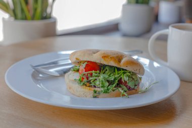 Beyaz tabakta Capsese ciabatta, tahta masada kahve.
