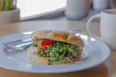 Beyaz tabakta Capsese ciabatta, tahta masada kahve.