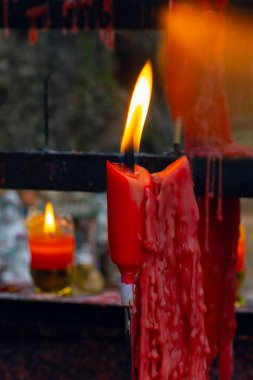 Çin 'in Zhuji şehrinde parkta kırmızı dua eden Budist mumlar.