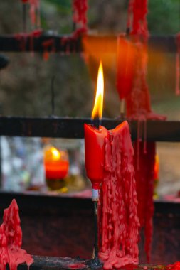 Çin 'in Zhuji şehrinde parkta kırmızı dua eden Budist mumlar.