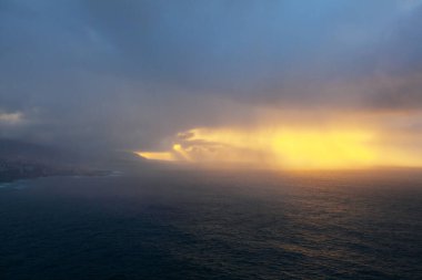 İnanılmaz gündoğumu ve ışınları İnanılmaz gün batımı, dramatik gökyüzü ve deniz üzerindeki ışınlar Santa Ursula, Kuzey Tenerife 'de denizi