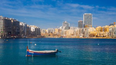 Malta - 9 Ferobot, 2024: Saint Julian Körfezi geleneksel renkli balıkçı tekneleri Luzzu, Malta