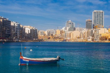 Malta - 9 Ferobot, 2024: Saint Julian Körfezi geleneksel renkli balıkçı tekneleri Luzzu, Malta