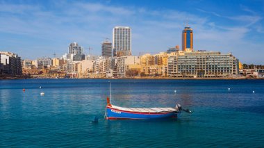 Malta - 9 Ferobot, 2024: Saint Julian Körfezi geleneksel renkli balıkçı tekneleri Luzzu, Malta