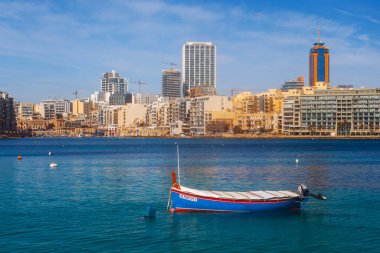 Malta - 9 Ferobot, 2024: Saint Julian Körfezi geleneksel renkli balıkçı tekneleri Luzzu, Malta