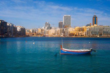 Malta - 9 Ferobot, 2024: Saint Julian Körfezi geleneksel renkli balıkçı tekneleri Luzzu, Malta