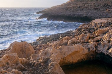 Kışın gün batımında Malta kıyısı ve kayalar