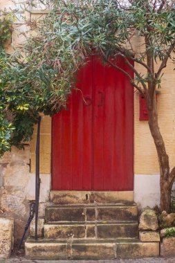Rabat 'ın Dar Caddesi' ndeki kırmızı kapılar. Geleneksel kireçtaşından yapılmış Malta evleri, Victoria, Malta.