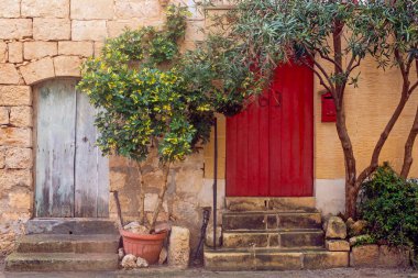 Rabat 'ın Dar Caddesi' ndeki kırmızı kapılar. Geleneksel kireçtaşından yapılmış Malta evleri, Victoria, Malta.