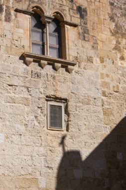 Mdina 'daki antik binalarda taş duvarlar, eski taş duvarlar ve Mdina' nın dar sokaklarında gölgeler, eski Malta 'nın başkenti.