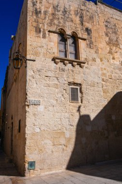Mdina 'daki antik binalarda taş duvarlar, eski taş duvarlar ve Mdina' nın dar sokaklarında gölgeler, eski Malta 'nın başkenti.