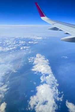 Bulutlar ve uçak penceresinden bir Wizzair Airbus kanadı. Malta adaları ve Akdeniz üzerinde