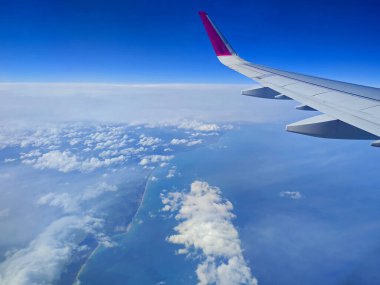 Bulutlar ve uçak penceresinden bir Wizzair Airbus kanadı. Malta adaları ve Akdeniz üzerinde