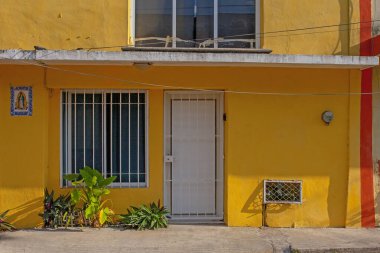 Merida, Yucatan, Meksika - 4 Nisan 2022: Merida şehrinin eski Meksika caddesindeki renkli sarı koloni tarzı binalar