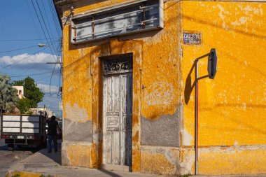 Merida, Yucatan, Meksika - 4 Nisan 2022: Merida şehrinin eski Meksika caddesindeki renkli sarı koloni tarzı binalar