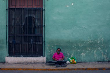 Merida, Meksika - 4 Nisan 2022: Merida sokaklarında renkli koloni tarzı binalarla müzisyen