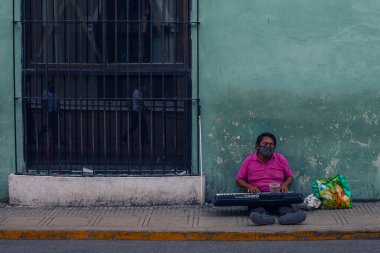 Merida, Meksika - 4 Nisan 2022: Merida sokaklarında renkli koloni tarzı binalarla müzisyen