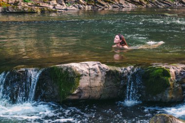 Karpatya dağlarında nehirde güzel genç bir kadın