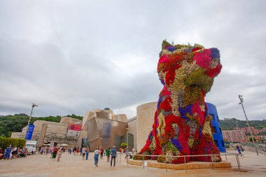 Bilbao, İspanya - 15 Temmuz 2024: Bilbao 'nun Guggenheim Müzesi' nin önünde duran çiçekli çalı ağacı İspanya 'nın beşinci büyük kentinin sembolüdür..