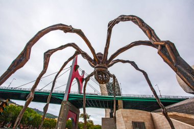 Bilbao, İspanya - 15 Temmuz 2024: Louise Bourgeois 'in Guggenheim Müzesi' ndeki heykeli ve La Salve nehri üzerindeki ünlü köprüsü 