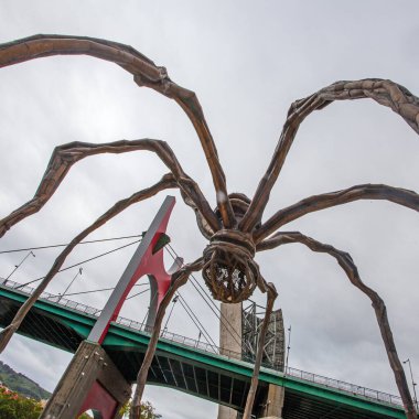 Bilbao, İspanya - 15 Temmuz 2024: Louise Bourgeois 'in Guggenheim Müzesi' ndeki heykeli ve La Salve nehri üzerindeki ünlü köprüsü 