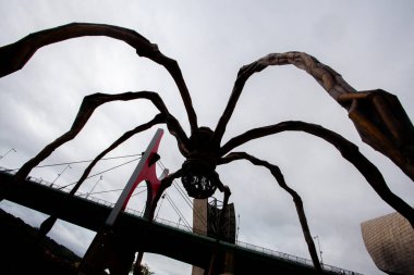 Bilbao, İspanya - 15 Temmuz 2024: Louise Bourgeois 'in Guggenheim Müzesi' ndeki heykeli ve La Salve nehri üzerindeki ünlü köprüsü 