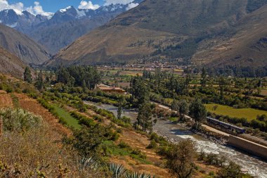 Ollantaytambo , Peru - May 3, 2022: Train heading through the Andes in Peru with stunning landscape, Ollantaytambo is the last stop to get train to Machu Picchu at Peru clipart