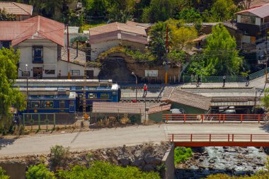 Ollantaytambo , Peru - May 3, 2022: Train heading through the Andes in Peru with stunning landscape, Ollantaytambo is the last stop to get train to Machu Picchu at Peru clipart