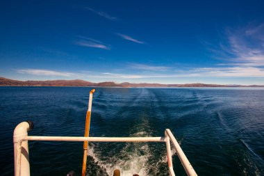 Peru 'daki Titicaca Gölü' nde, motorlu teknenin arkasındaki su yüzeyinde iz var.