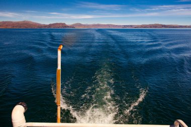 Trail on water surface behind of motor boat on lake Titicaca, Peru clipart