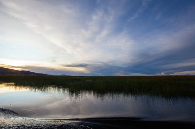 Güzel titicaca gölü ve Andes dağları günbatımında, Puno, Peru 'daki tur sırasında gemiden alınmıştır.