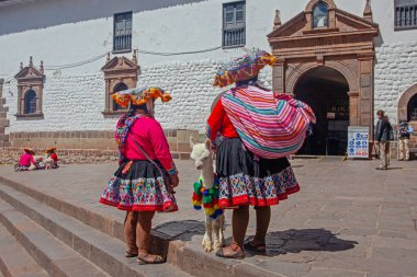 Cuzco, Peru - 13 Mayıs 2022: Cuzco 'da geleneksel giyinmiş Perulu insanlar. Cusco, Peru 'da Lama' nın yanındaki kadın.,