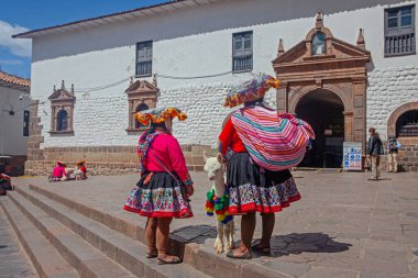Cuzco, Peru - 13 Mayıs 2022: Cuzco 'da geleneksel giyinmiş Perulu insanlar. Cusco, Peru 'da Lama' nın yanındaki kadın.,
