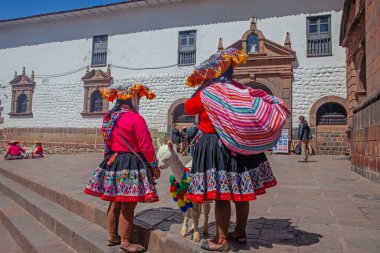 Cuzco, Peru - 13 Mayıs 2022: Cuzco 'da geleneksel giyinmiş Perulu insanlar. Cusco, Peru 'da Lama' nın yanındaki kadın.,