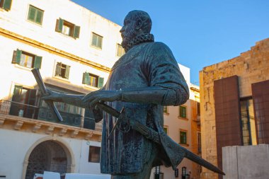 Valletta, Malta - February 13, 2024: Bronze statue of Grand Master Jean Parisot  de Vallette, in Pjazza Jean de Vallette, with Our Lady of Victories Chapel behind, clipart