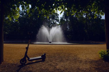 Scooter in Brussels park near the fountain taken in early sunny morning , Belgium clipart