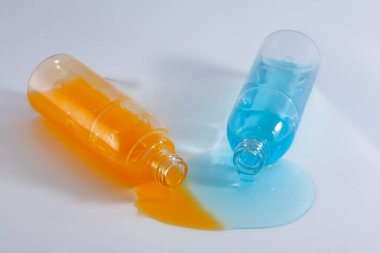 Dökülmüş renkli şampuan şişeleri, beyazın üstüne