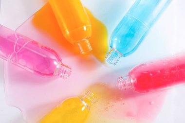Dökülmüş renkli şampuan şişeleri, beyazın üstüne