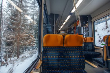 Poprad, Slovakya - 16 Aralık 2024: Modern elektrikli trenin vagonundan Slovakya 'daki Strbske Pleso' ya giden Tatres dağlarına bakın.