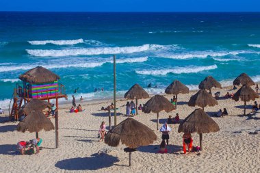 Cancun, Yucatan, Meksika - 10 Mart 2022: Playa Delfines bu tropikal şehrin en ünlü plajlarından biridir. Birçok insan yaz boyunca manzaranın tadını çıkarmak için gelir..