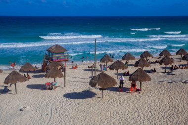 Cancun, Yucatan, Meksika - 10 Mart 2022: Playa Delfines bu tropikal şehrin en ünlü plajlarından biridir. Birçok insan yaz boyunca manzaranın tadını çıkarmak için gelir..