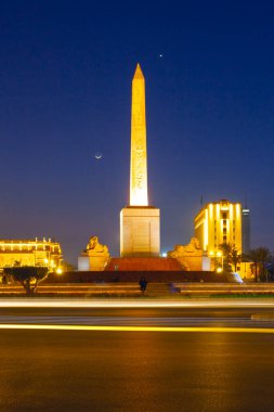 Kahire, Mısır - 1 Mart 2025: Meşhur Ramses II dikilitaş ve Tahrir Meydanı trafik, akşam manzaralı, Kahire, Mısır 