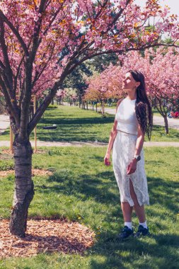 Kyiv 'deki Sakura bahçe parkında beyaz elbiseli güzel bir kadın.