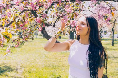 Kyiv 'deki Sakura bahçe parkında beyaz elbiseli güzel bir kadın.