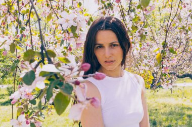 Kyiv 'deki Sakura bahçe parkında beyaz elbiseli güzel bir kadın.