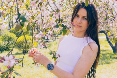 Kyiv 'deki Sakura bahçe parkında beyaz elbiseli güzel bir kadın.